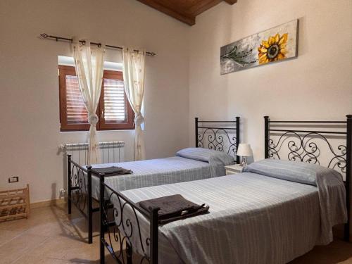 a bedroom with two beds and a sunflower picture on the wall at CASALE ANTICO SOBBORGO in Vitorchiano