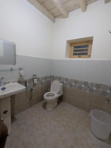 a bathroom with a toilet and a sink at Passu Didargah Resort in Pasu