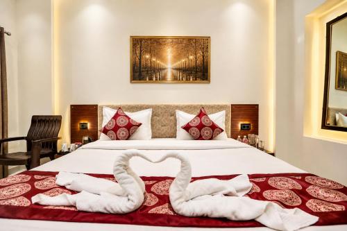 a bedroom with a bed with two swans forming a heart at Hotel Vibe Blu Near JHV Mall in Varanasi