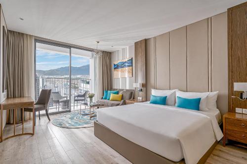 a hotel room with a large bed and a balcony at Crystal Bay Premier Suites in Nha Trang