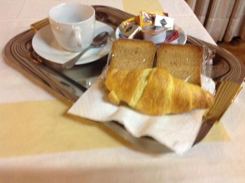 a tray with two slices of bread and a cup of coffee at Ristorante Albergo Roma in Legnano