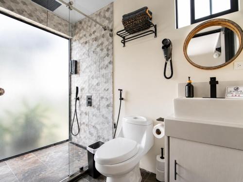 a bathroom with a toilet and a shower at Villa Los Perezosos - Private Jacuzzi & Arenal Volcano View - La Fortuna in Fortuna