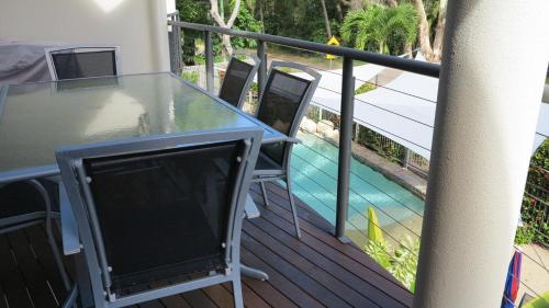 a table with a television on a balcony with a pool at Sol Y Olas Sun and Waves in Arcadia