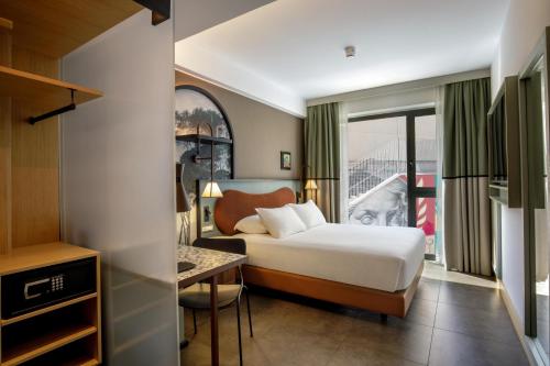 a hotel room with a bed and a desk at The Spring House Hotel Rome Vatican, Tapestry Collection Hilton in Rome
