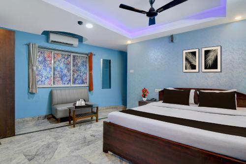 a bedroom with a large bed and a couch at Hotel O Calcutta University Formerly Hamza International in Kolkata