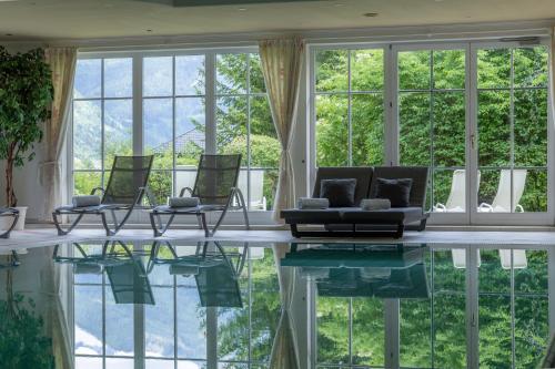 a living room with a pool and windows at Hotel Zum Stern inkl Gasteiner Bergbahnen im Sommer in Bad Hofgastein