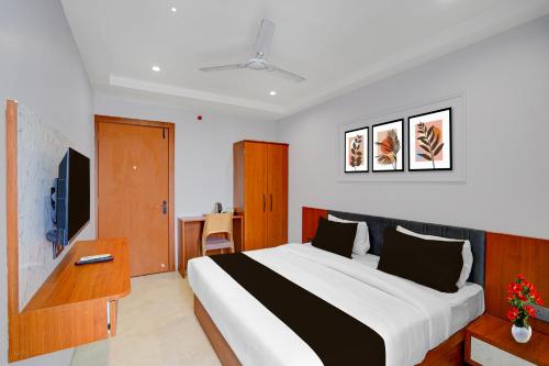a bedroom with a large bed and a television at Townhouse Oak Ujjain Railway Station Formerly Kasliwal Inn in Ujjain