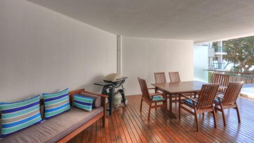 a dining room with a table and chairs and a dog at Maggies Beachfront Apartment 11 in Horseshoe Bay