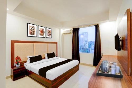 a bedroom with a large bed and a window at Super Collection O Friends Colony Lucknow Formerly The Suite in Lucknow
