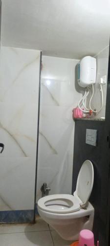 a bathroom with a white toilet in a room at Hotel Gaurav in Ahār