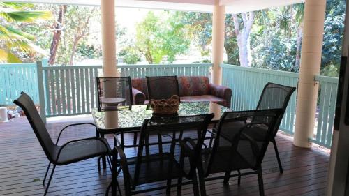a table and chairs on a porch with a couch at Lanas Cottage in Arcadia