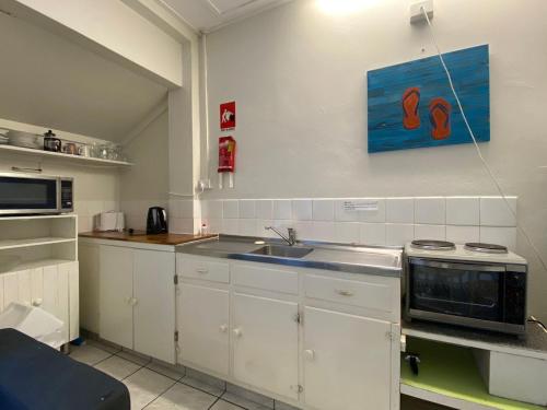 a kitchen with a sink and a microwave at The Captains Manor on Cook 8 in Arcadia