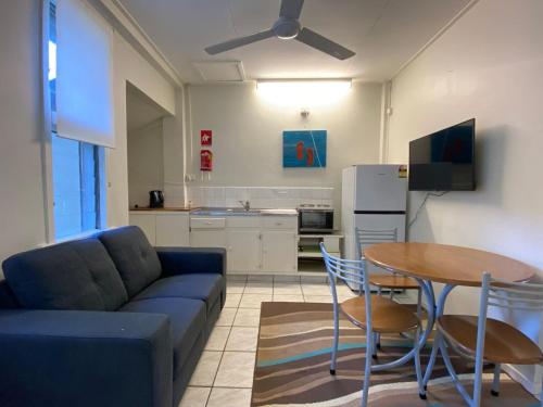 a living room with a couch and a table and a kitchen at The Captains Manor on Cook 8 in Arcadia
