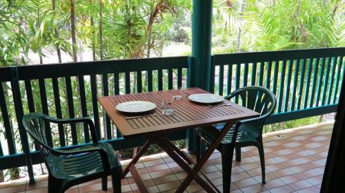a wooden table and two chairs on a balcony at Magnetic Reef 7 in Arcadia