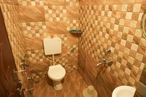 a bathroom with a toilet and a shower with tiles at Hostel Mama in Udaipur
