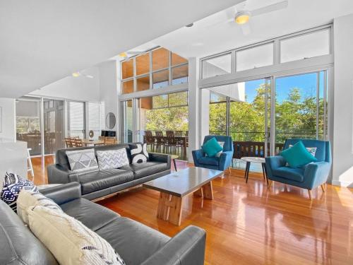 a living room with couches and chairs and a table at Maggies Beachfront Apartment 12 in Horseshoe Bay