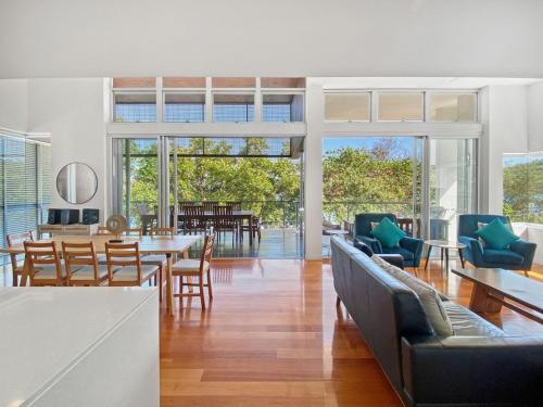 a living room with a couch and tables and chairs at Maggies Beachfront Apartment 12 in Horseshoe Bay