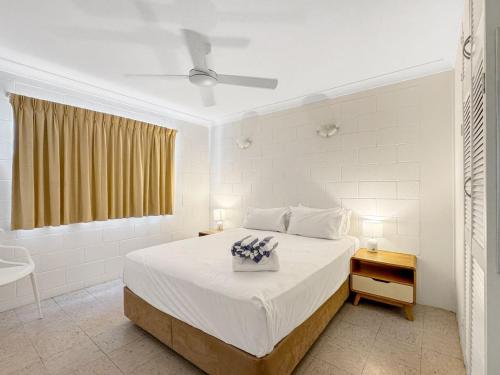 a white bedroom with a bed and a window at Arcadia Palms 1 in Arcadia