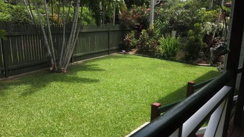 a backyard with a lawn with a fence at Arcadia Gardens in Arcadia