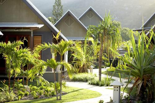 a house with palm trees in front of it at Pure Magnetic Villa 3 in Nelly Bay