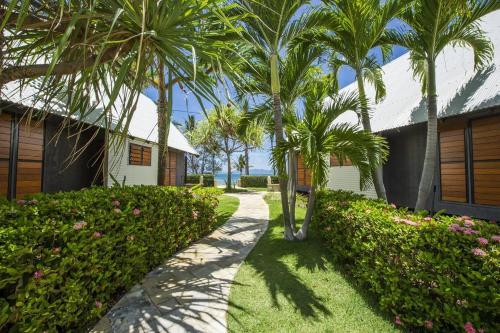 a walkway with palm trees next to a building at Pure Magnetic Villa 3 in Nelly Bay