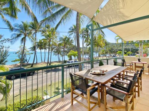 a table on a balcony with a view of the ocean at Sails on Horseshoe Apartment 4 in Horseshoe Bay