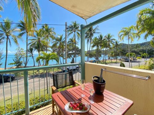 a table with a plate of fruit on a balcony at Sails on Horseshoe Apartment 4 in Horseshoe Bay