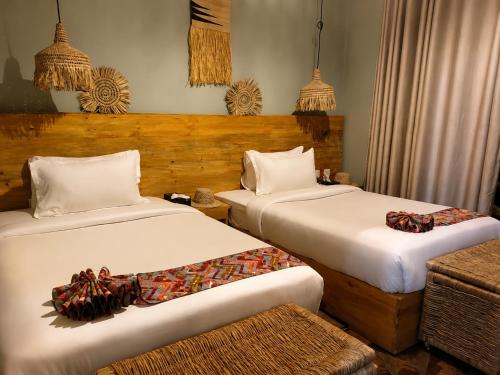 a bedroom with two beds and a couch at Akagera Park Inn in Akagera