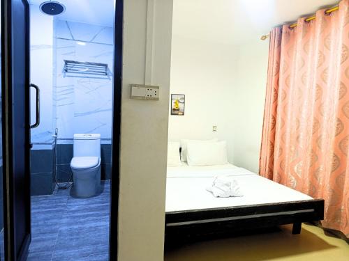a small bathroom with a bed and a shower at Invito Guesthouse in Sihanoukville