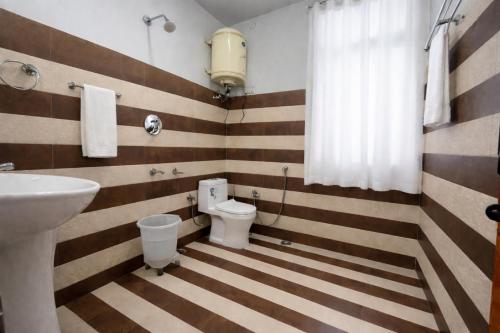a bathroom with a sink and a toilet at The Himalayan Nomad Manali - 2 bedrooms mountain view independent villas with personal lawn in Manāli
