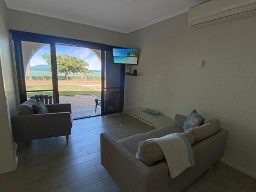 a living room with a couch and a flat screen tv at Beachside Palms Unit 3 in Nelly Bay