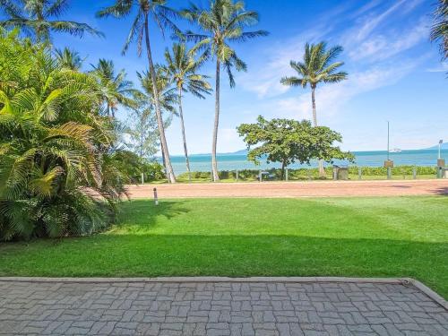 a park with palm trees and the ocean in the background at Beachside Palms Unit 3 in Nelly Bay