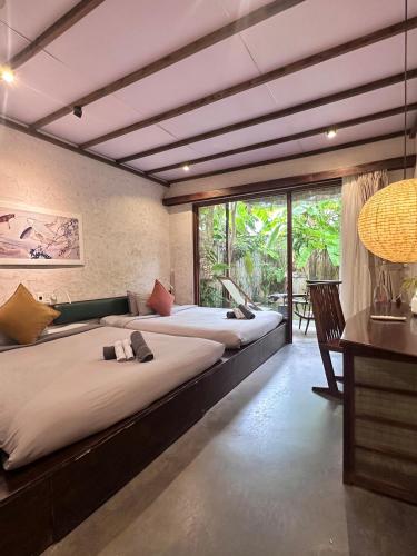 a room with three beds and a desk and a window at CasaWa Homestay Hue in Thôn Trường Giang