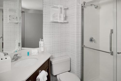 a bathroom with a toilet and a sink and a shower at Hampton Inn Janesville in Janesville