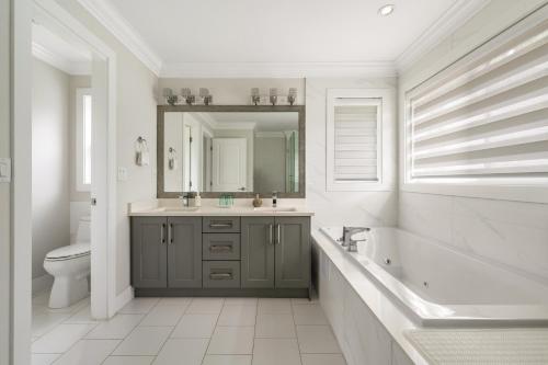 a bathroom with a sink and a toilet and a mirror at 5-Star Luxury and comfortable home in New Westminster