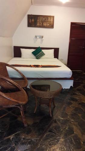 a bedroom with a bed and a table and a chair at Papillon Resort in Chaweng