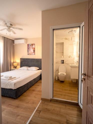 a bedroom with a bed and a toilet and a sink at Guestrooms Zoya in Chernomorets