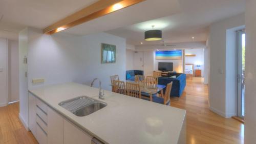 a kitchen and living room with a sink and a table at Maggies Beachfront Apartment 6 in Horseshoe Bay