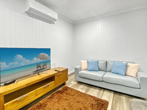 a living room with a couch and a flat screen tv at Magnetic Reef Unit 2 in Arcadia
