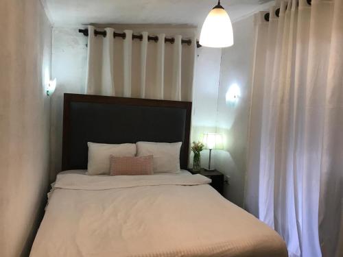 a bedroom with a large bed with white sheets at Fair Field Bungalow in Nuwara Eliya