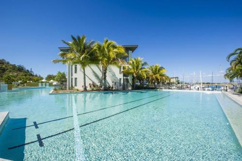 a large swimming pool with a fountain in front of a building at Blue on Blue Apartment 912 in Nelly Bay