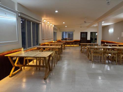 a dining room with wooden tables and chairs at Cedar wave in Munsyari