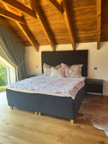 a large bed in a room with wooden ceilings at chata Jarka in Jivno