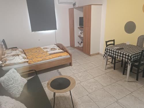 a bedroom with a bed and a table and chairs at Imanje Mihailovic 2 in Pružatovac