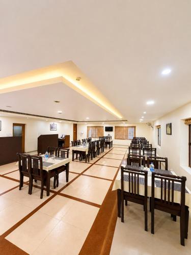 a restaurant with tables and chairs in a room at Hotel Xavier's Avenue in Kadavoor