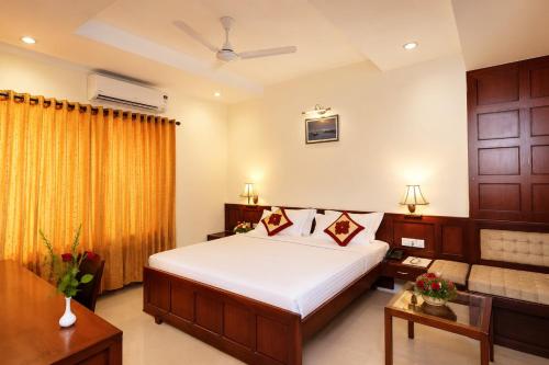 a bedroom with a large bed and a couch at Hotel Xavier's Avenue in Kadavoor