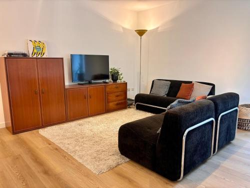 a living room with a couch and a tv at Verblijf in het Pajottenland in Gooik