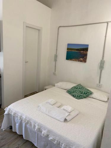 a white bed with two towels on top of it at Salento Sunny Flat in Aradeo