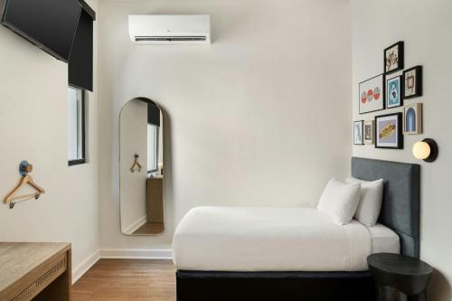 a bedroom with a white bed and a mirror at FOUND Hotels, Chicago, Series by Marriott in Chicago