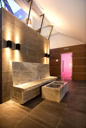 a bathroom with a large stone sink and a pink door at Hotel Garni Fimba in Ischgl